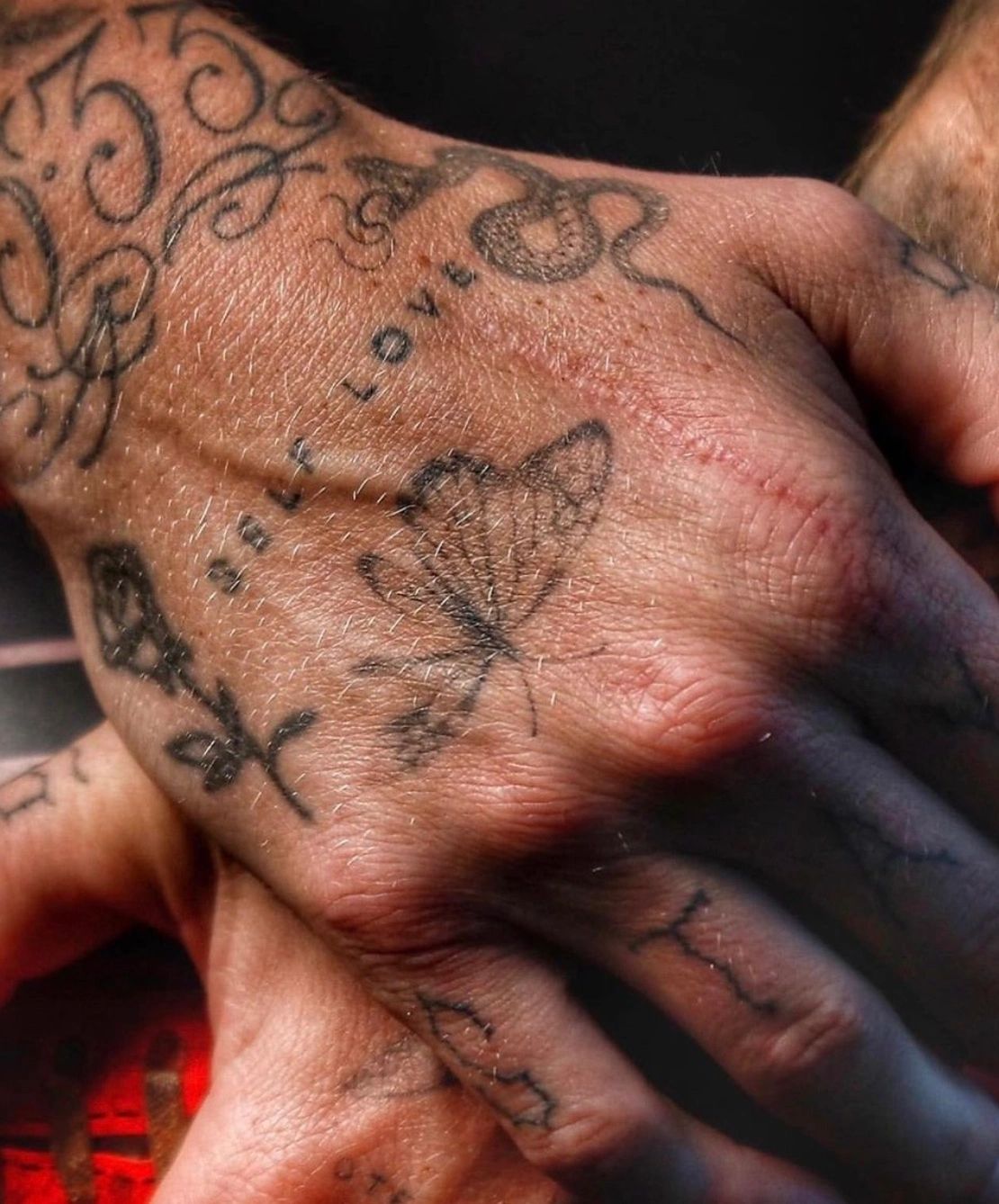 Self-love text surrounded by other imagery tattoo